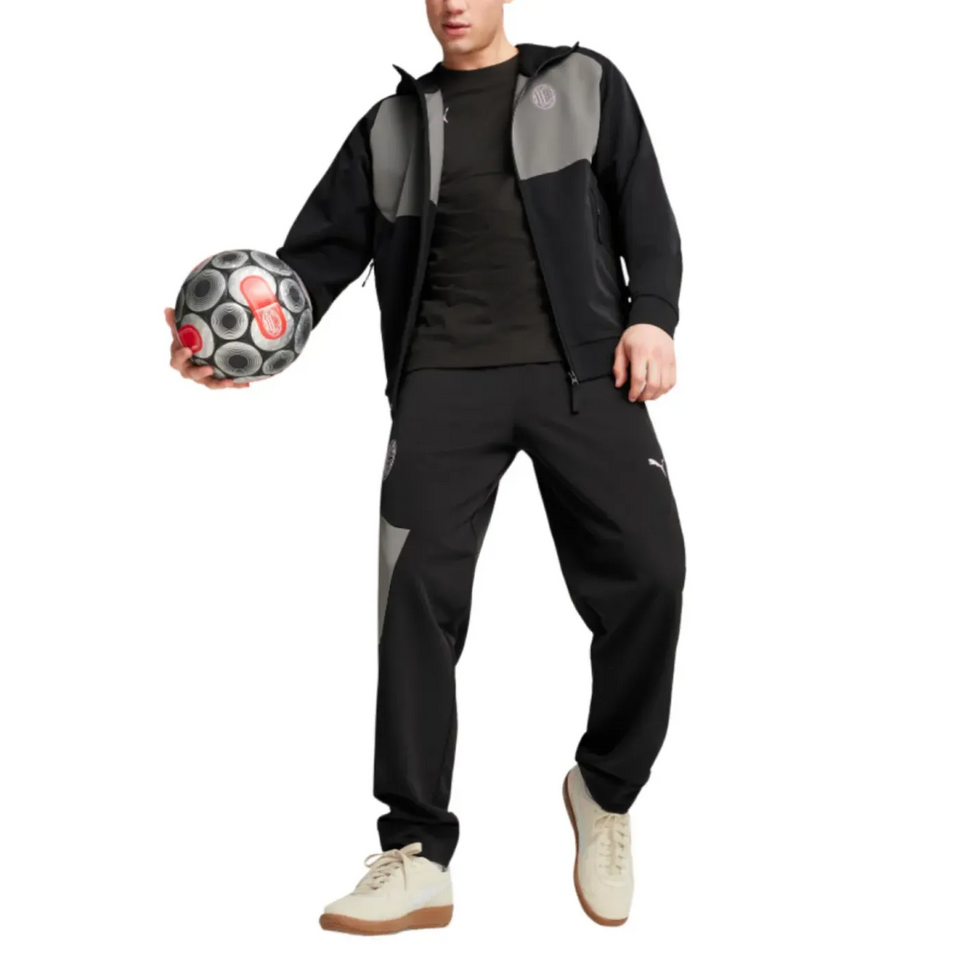 Athlete wearing AC Milan woven tracksuit 2024 25, featuring a stylish black design, ready for training