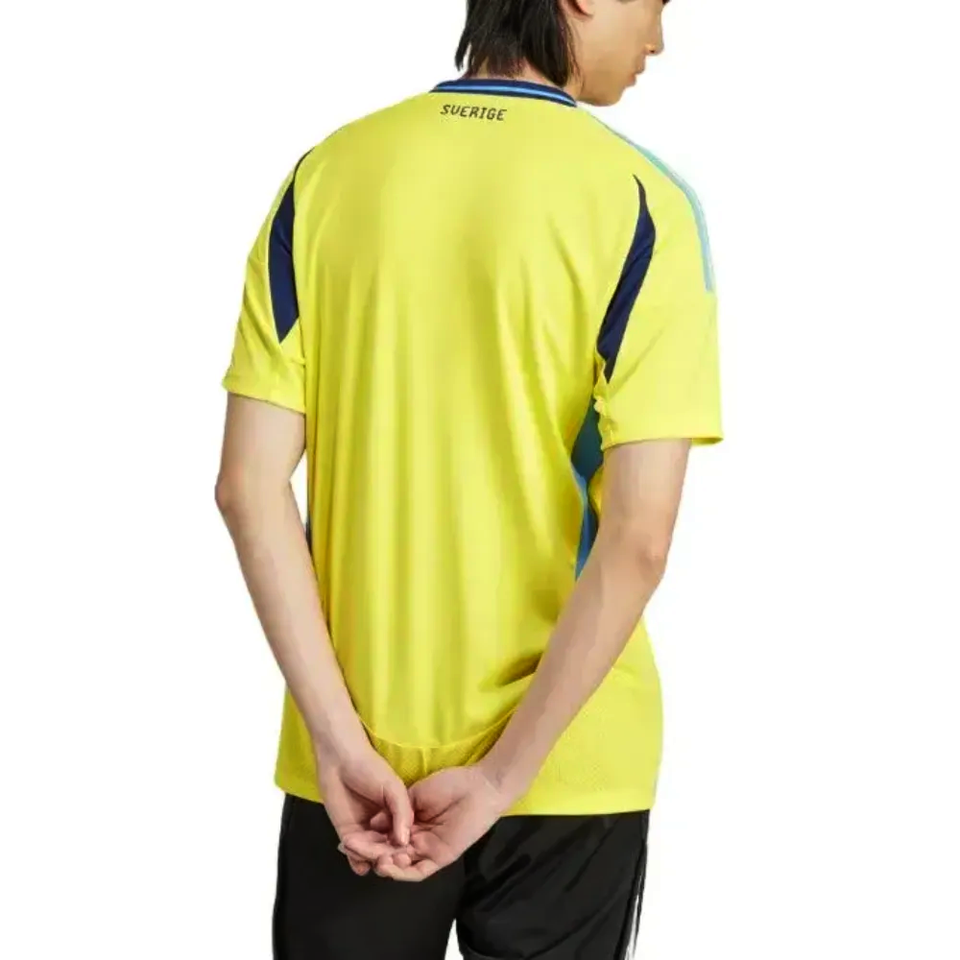 Back view of model wearing bright yellow Adidas Sweden soccer jersey 2024 25 with navy side panels and black shorts