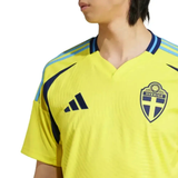 Adidas Sweden soccer jersey 2024 25 yellow home shirt close up with Sweden crest Adidas logo and blue shoulder stripes