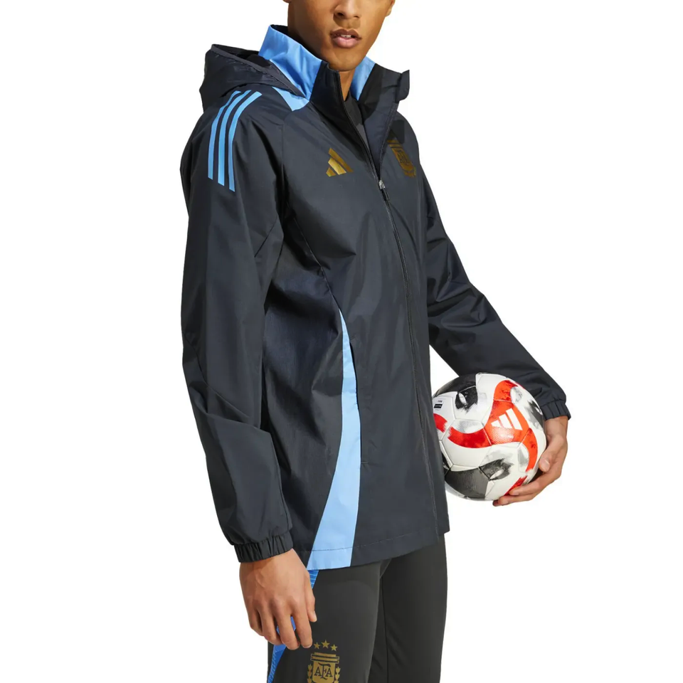 Soccer Tracksuits Argentina soccer rain jacket 2024 in black with blue stripes worn by model holding soccer ball