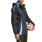 Soccer Tracksuits Argentina soccer rain jacket 2024 in black with blue stripes worn by model holding soccer ball