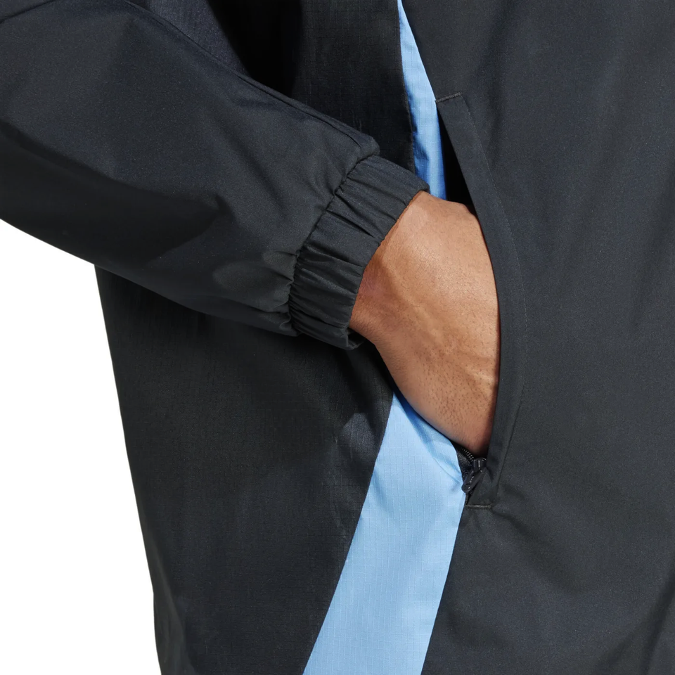 Close-up of Argentina soccer rain jacket 2024 with black fabric and light blue side panel pocket detail