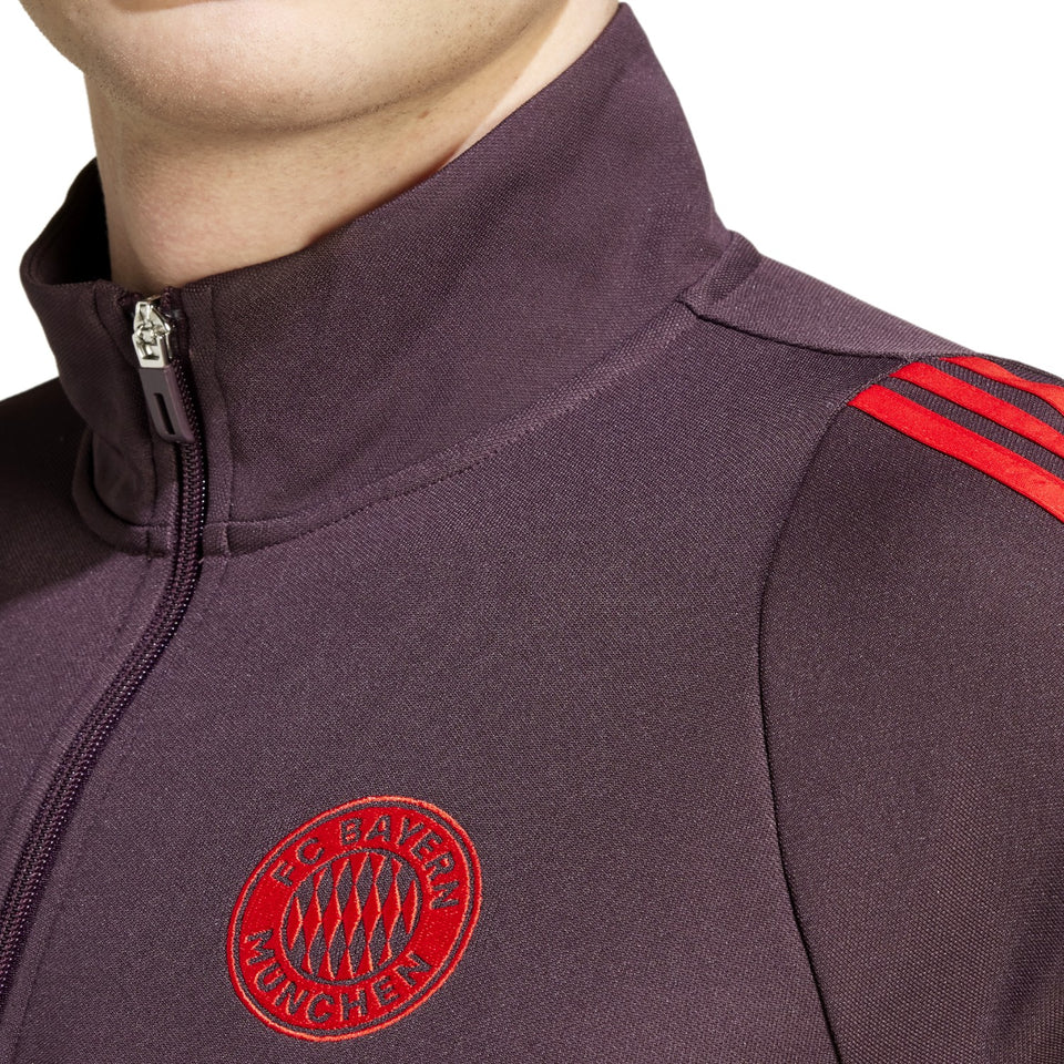 Close-up of Adidas Bayern Munich 2024 soccer tracksuit jacket with red FC Bayern Munich logo and red stripes on shoulder