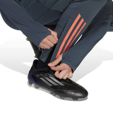 Adidas Bayern Munich training set for kids featuring adjustable pants with orange stripes and soccer cleats