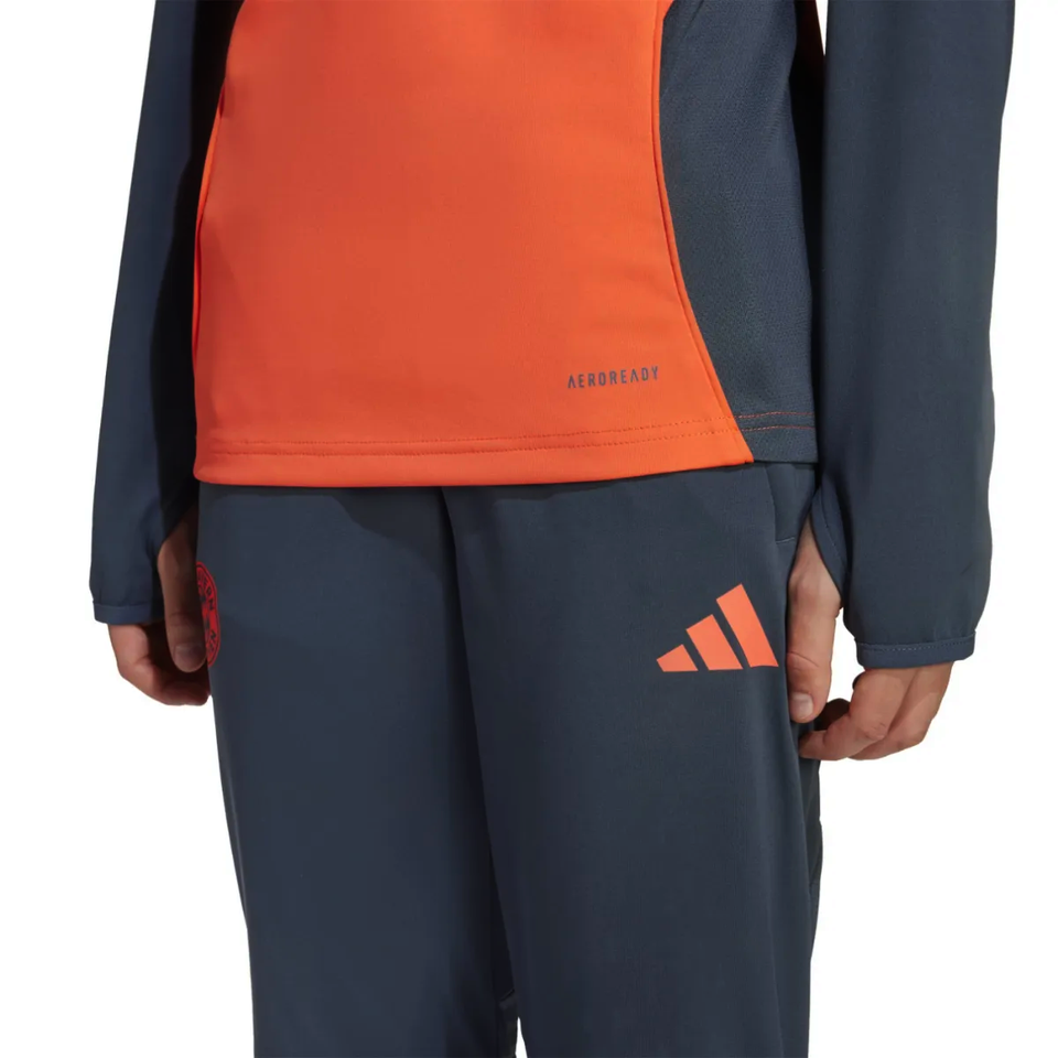 Adidas Bayern Munich training set for kids featuring a vibrant orange top and navy blue pants