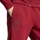Close-up of Adidas Belgium hooded tracksuit maroon pants with Belgium emblem and hand in pocket