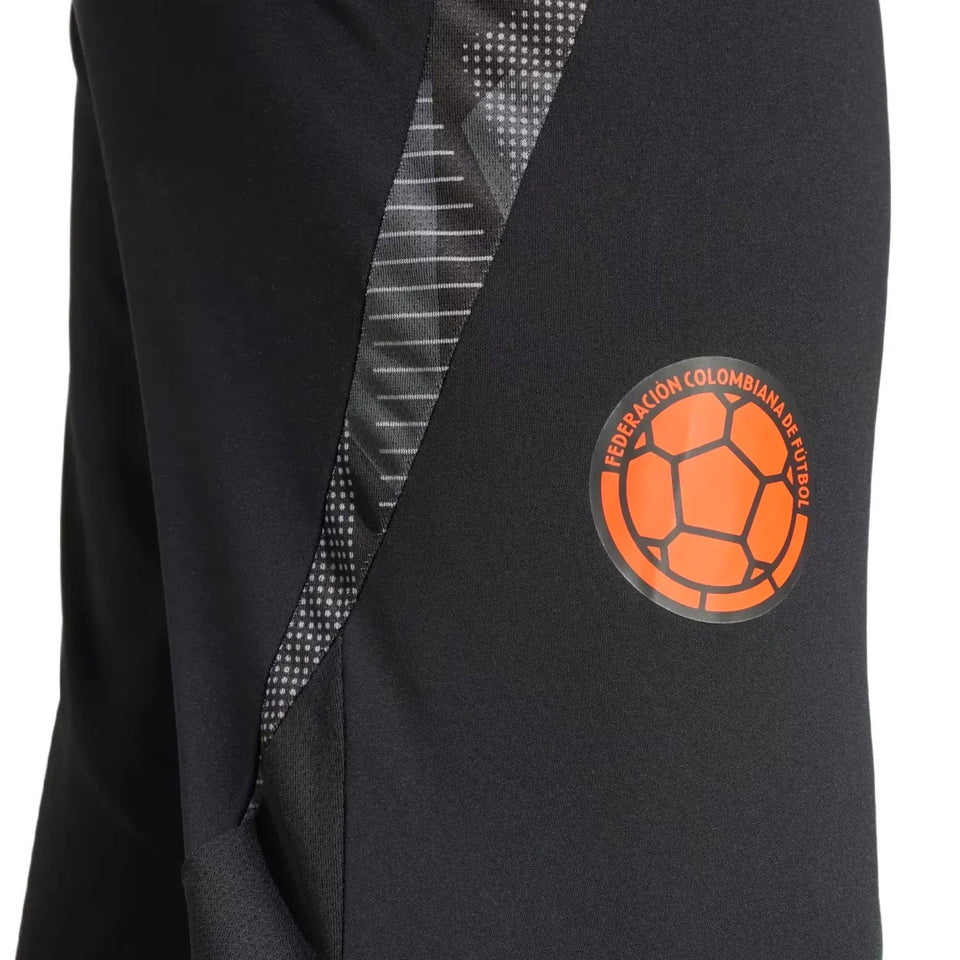 Close-up of black Adidas Colombia training suit pants with orange Colombia soccer emblem