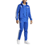 Man wearing blue Italy Adidas Originals tracksuit with white three stripes zip jacket and tapered pants