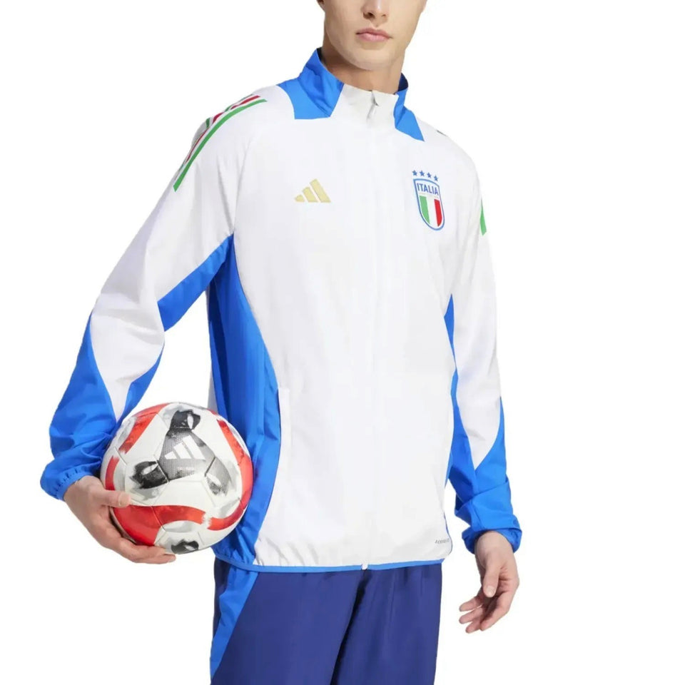 Male model wearing Italy national team presentation tracksuit white blue jacket with crest holding soccer ball