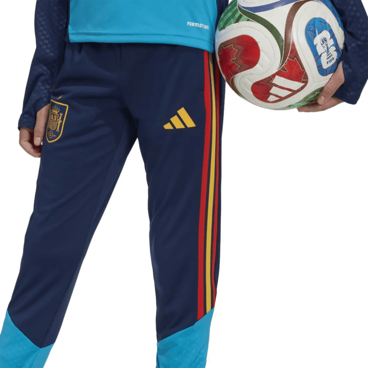 Kids Adidas Spain training technical soccer tracksuit in blue with red and yellow stripes, featuring pants and top.