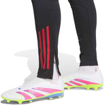 Close-up of black Liverpool FC hooded training tracksuit pants with red stripes and white soccer cleats