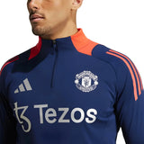 Close-up of blue and red Manchester United 2024 training tracksuit top with zipper and sponsor logos