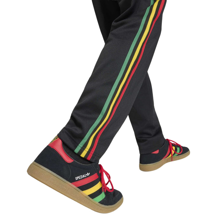 Black sneakers with red, yellow, and green stripes and laces from the brand Special.