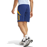 Back view of blue and yellow shorts from Real Madrid training kit 2024 worn by male model