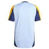 Back view of Real Madrid training kit 2024 with light blue, navy, and yellow color scheme