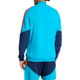 Person wearing a blue Adidas x Spain tracksuit with colorful side panels on a white background
