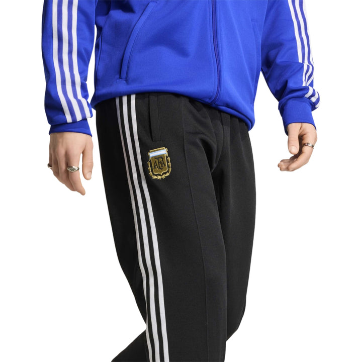 Black Adidas track pants with white stripes and embroidered logo