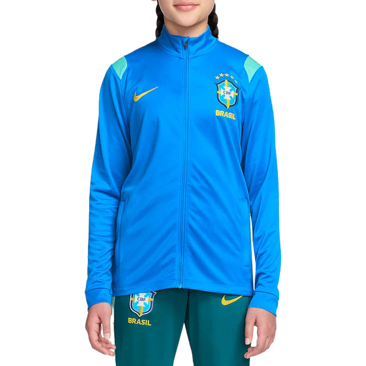 Girl wearing a Nike x Brazil blue and green presentation tracksuit with Nike logo on a white background