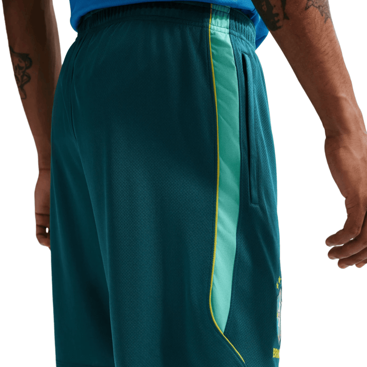 Men's teal athletic shorts with side pockets and yellow trim, featuring a logo on the left leg.