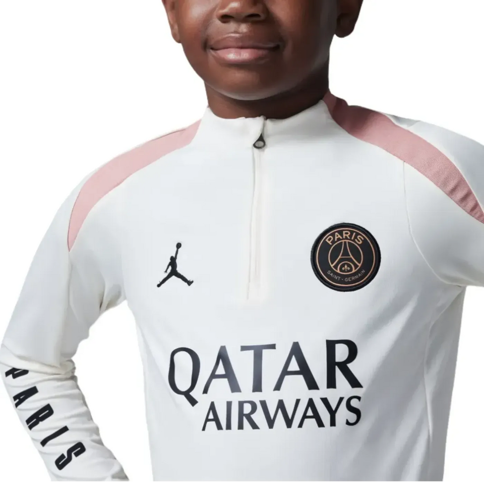 Boy wearing PSG Jordan kids tracksuit in white with pink accents. Buy PSG Jordan kids tracksuit online on SoccerTracksuits.com