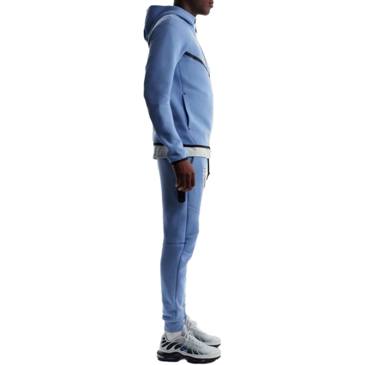 Light blue tracksuit with hood and zipper, featuring a slim fit and made of polyester.