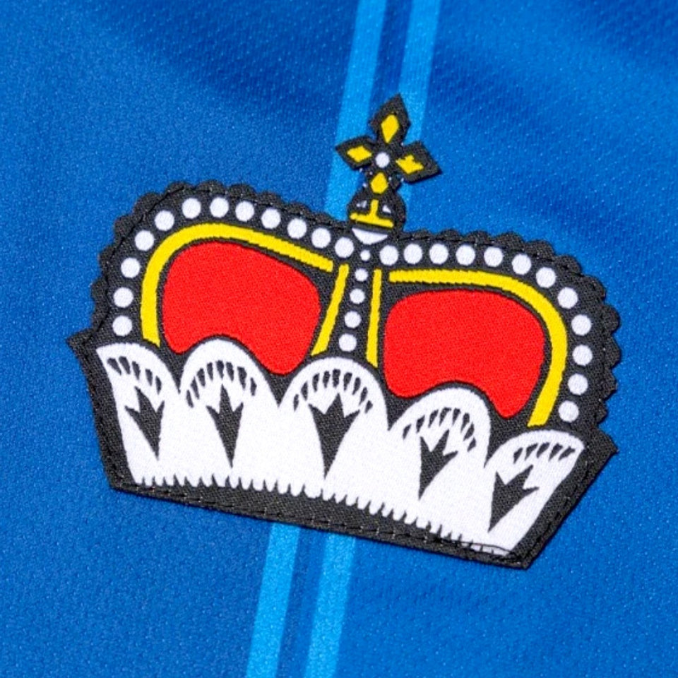 Close-up of embroidered crown logo on blue Liechtenstein home soccer jersey 2024