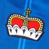Close-up of embroidered crown logo on blue Liechtenstein home soccer jersey 2024