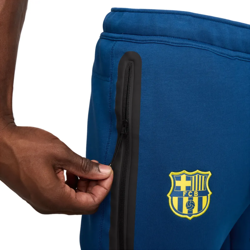 Close-up of FC Barcelona blue Tech Fleece tracksuit 2026 showing zip pockets and club logo