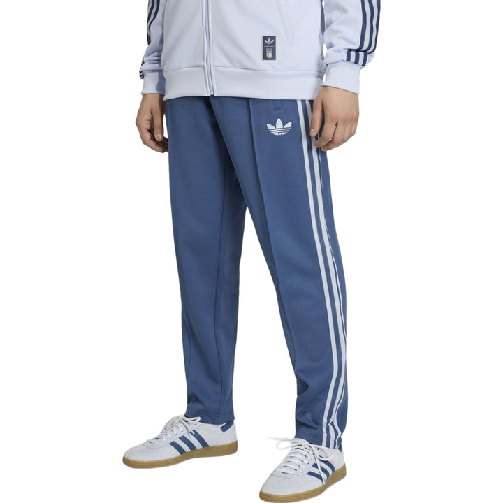 Blue Adidas track pants with three stripes and logo on the side
