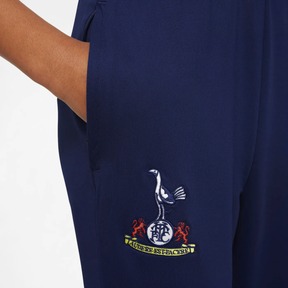 Close-up of kids Tottenham Hotspur UCL tracksuit 2025 featuring club logo on dark blue fabric
