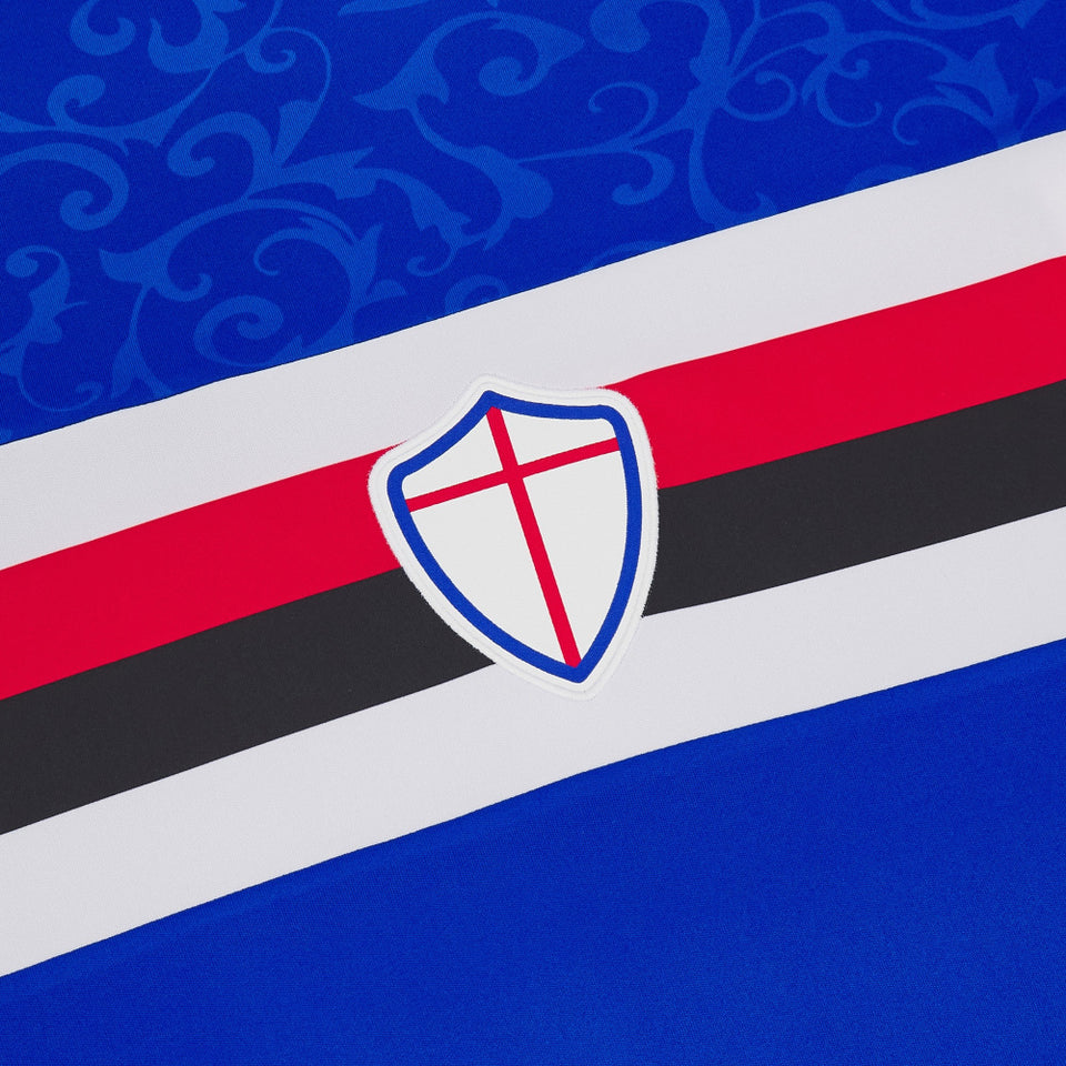 Close up of UC Sampdoria home jersey 2024 25 showing crest and red black white stripes on blue fabric
