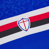 Close up of UC Sampdoria home jersey 2024 25 showing crest and red black white stripes on blue fabric