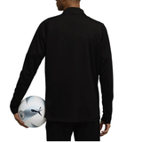 Back view of a model wearing the Manchester City black training top 2025, holding a soccer ball