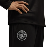 Close-up of Manchester City black training tracksuit 2025 featuring logo on SoccerTracksuits.com