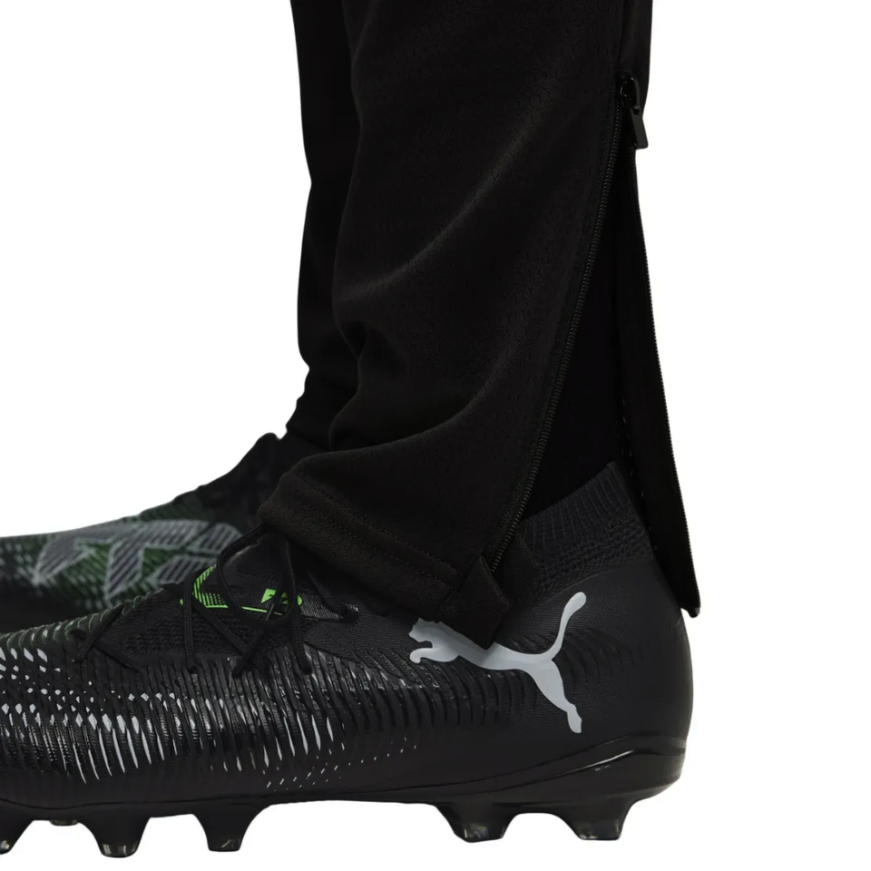 Close-up of a player wearing the Manchester City black training tracksuit 2025 with stylish Puma soccer cleats