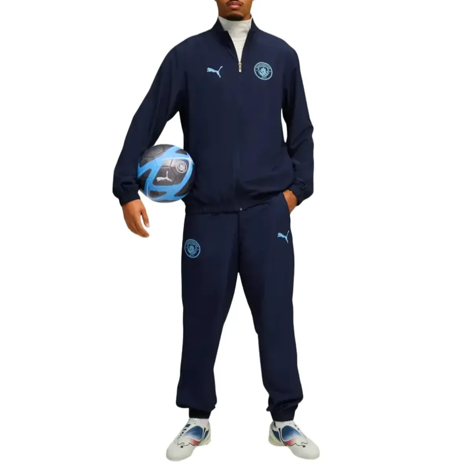 Man wearing Manchester City woven tracksuit 2025 26 with matching football and sporty accessories