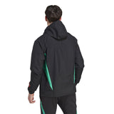 Back view of a man wearing Manchester United black rain jacket 2023 with green side panels and hood