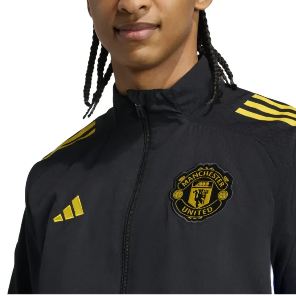 Manchester United black UCL tracksuit 2025 featuring a zip-up jacket with logo and yellow accents