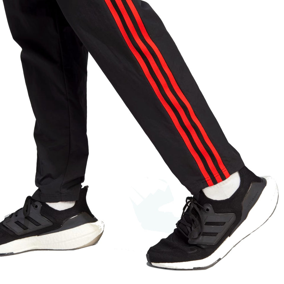 Manchester United presentation tracksuit 2023 featuring stylish black pants with red stripes