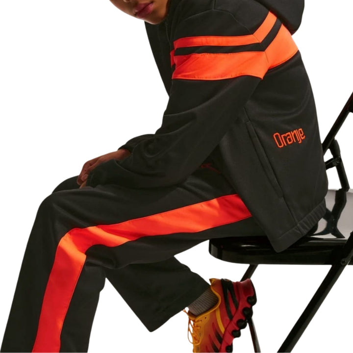 Kids Netherlands 2026/27 casual presentation soccer tracksuit in black and orange by Soccer Tracksuits