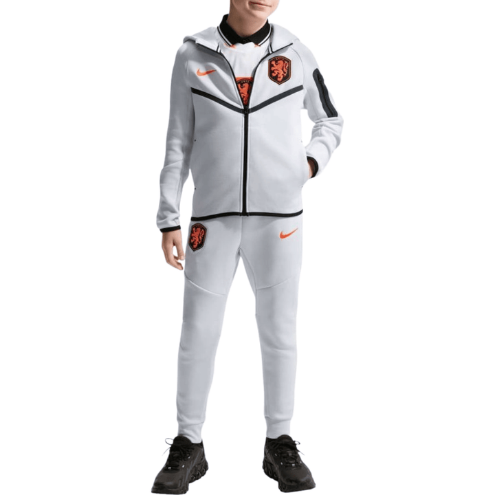 White Nike tracksuit for kids with orange logo and lion emblem on jacket and pants