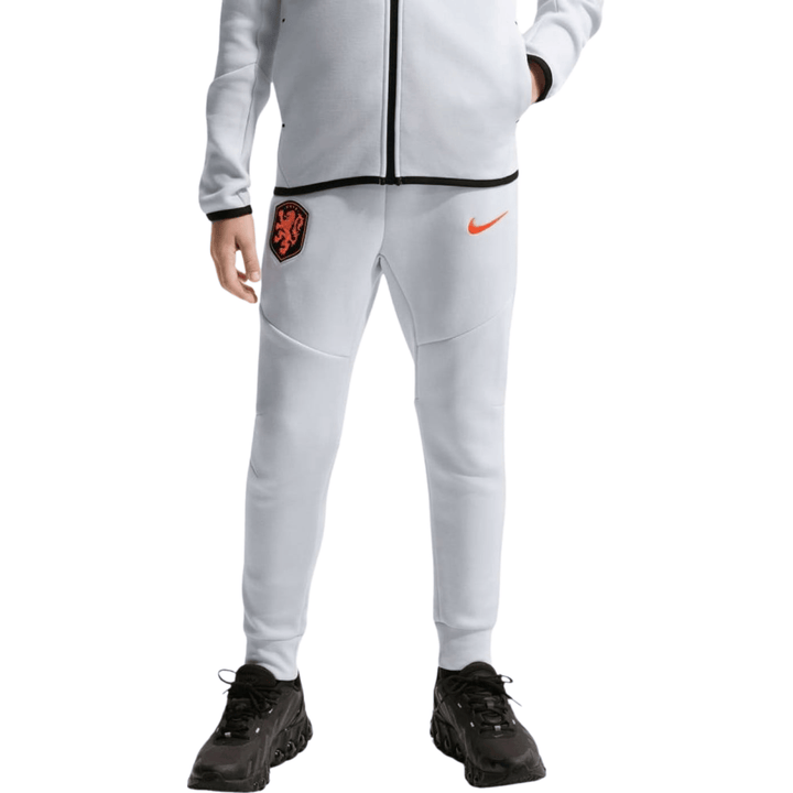 Light grey Nike Tech Fleece jogger pants with elastic waistband and orange logo for kids