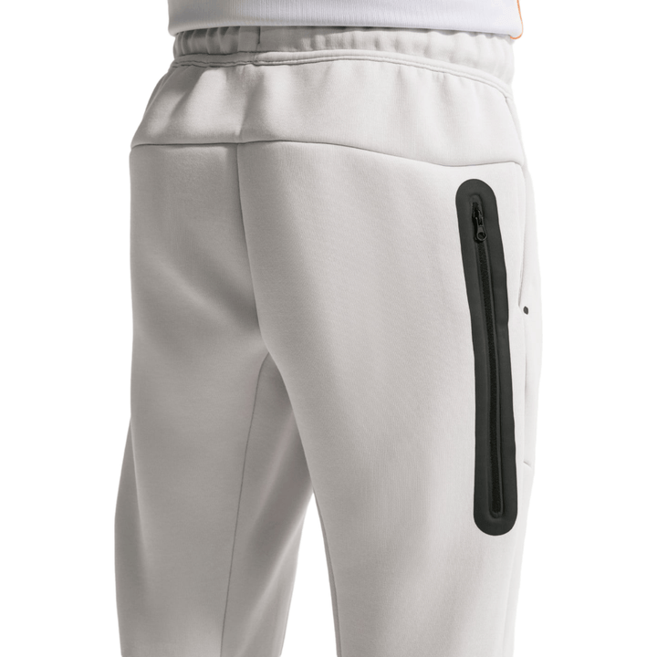 Men's light gray Tech Fleece jogger pants with side zipper pockets and elastic waistband