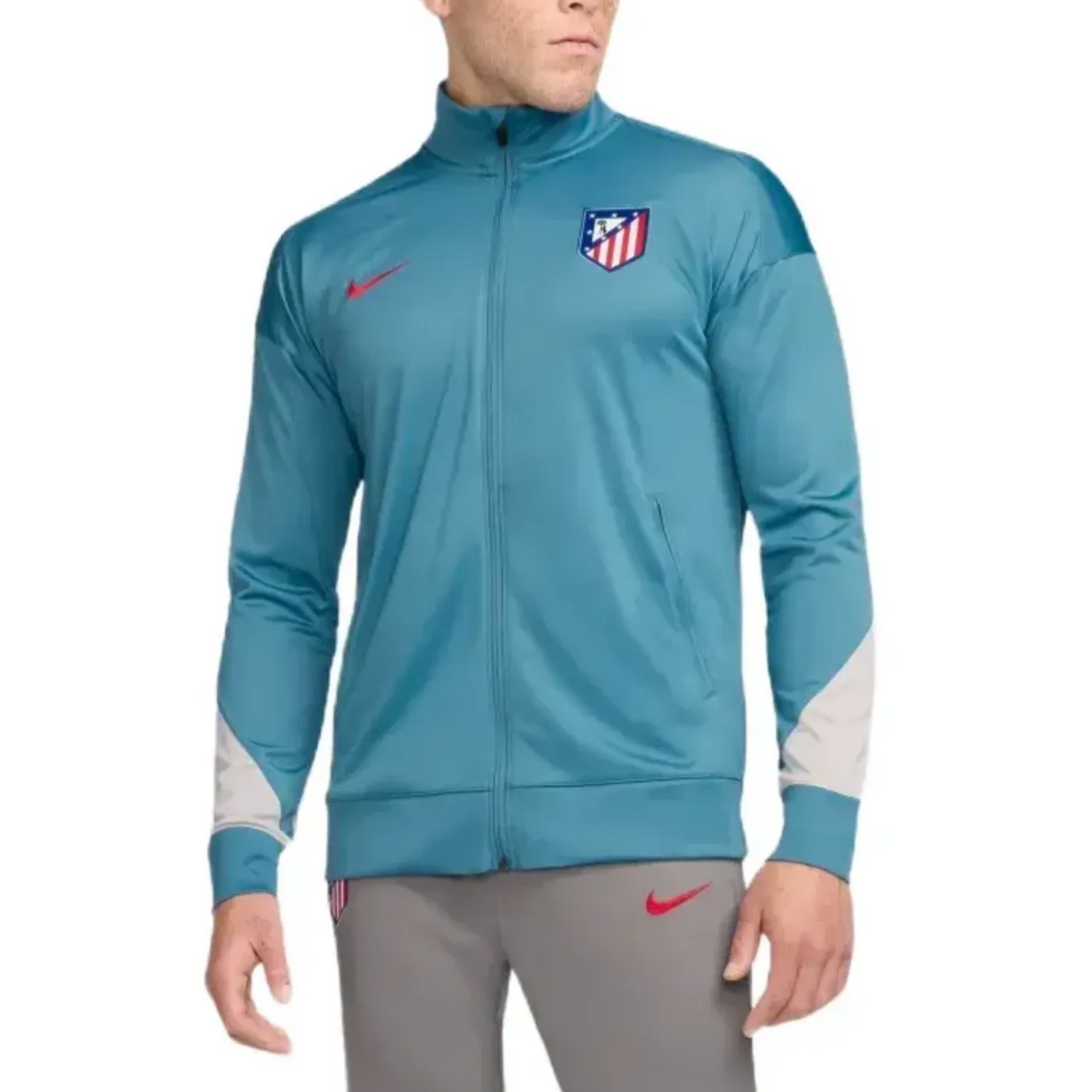 Atletico Madrid soccer tracksuit for sale featuring blue zip-up jacket with club crest and grey pants