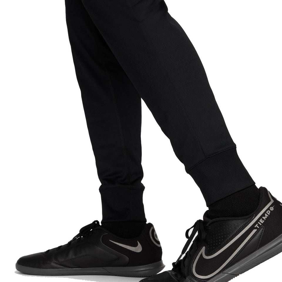 Close-up of black pants and black Nike Tiempo soccer shoes with Nike Chelsea UCL presentation suit