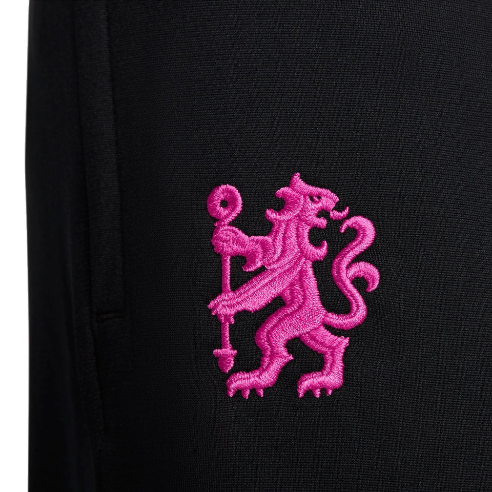 Close-up of pink lion emblem embroidery on black fabric of Nike Chelsea UCL presentation suit