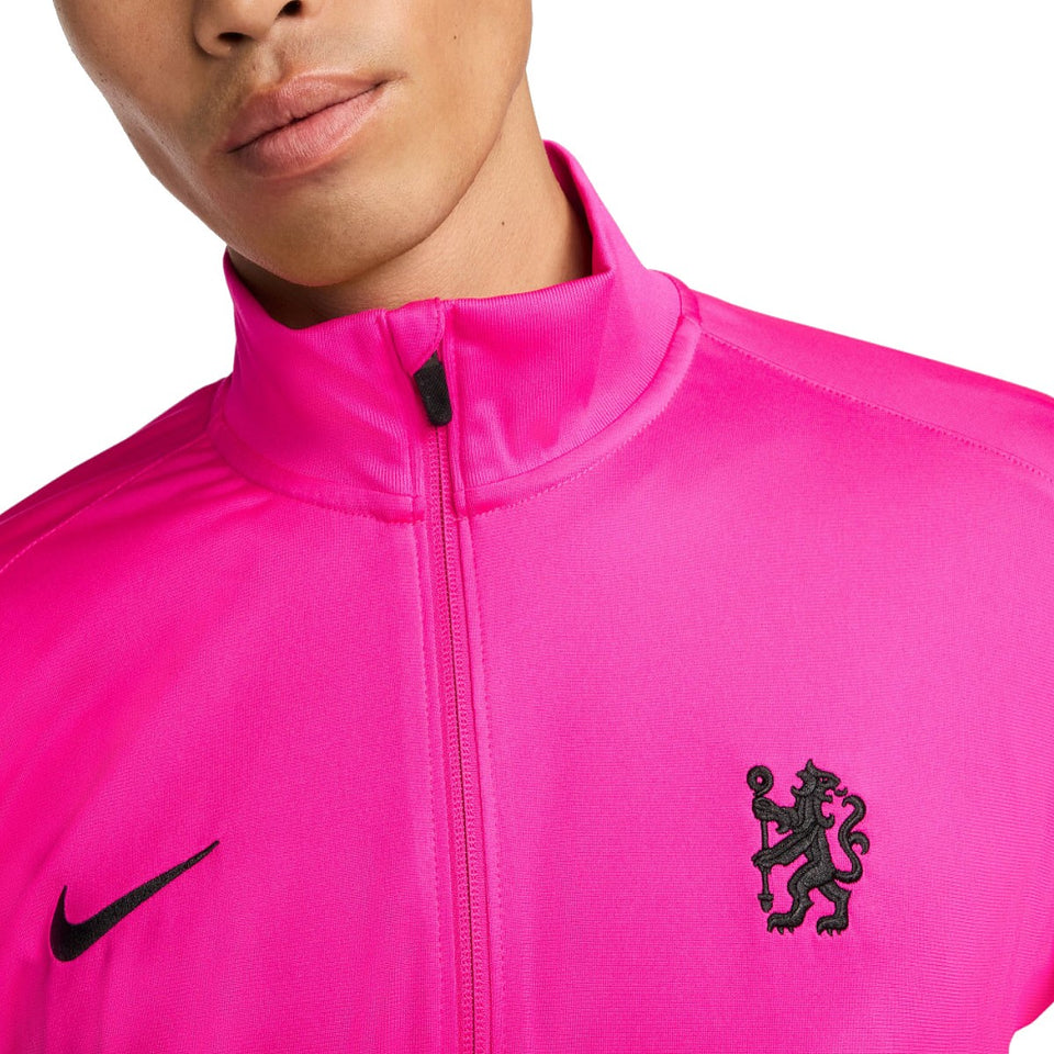 Close-up of Nike Chelsea UCL presentation suit in bright pink with embroidered black lion and Nike logo