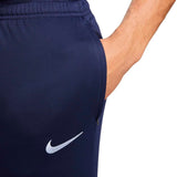 Close-up of navy blue France soccer tracksuit 2024 pants with Nike logo and hand in pocket