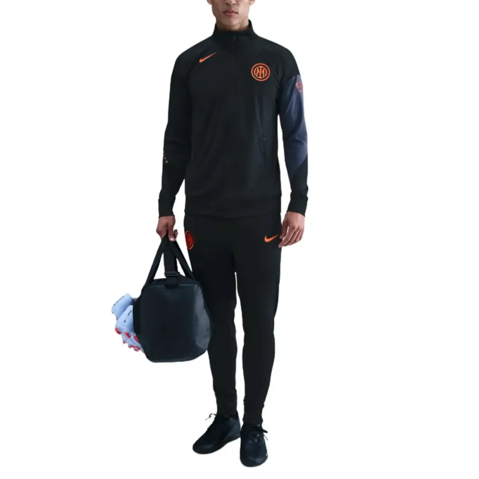 Male model wearing Inter Milan Nike UCL tracksuit 2025 26 with a stylish athletic bag