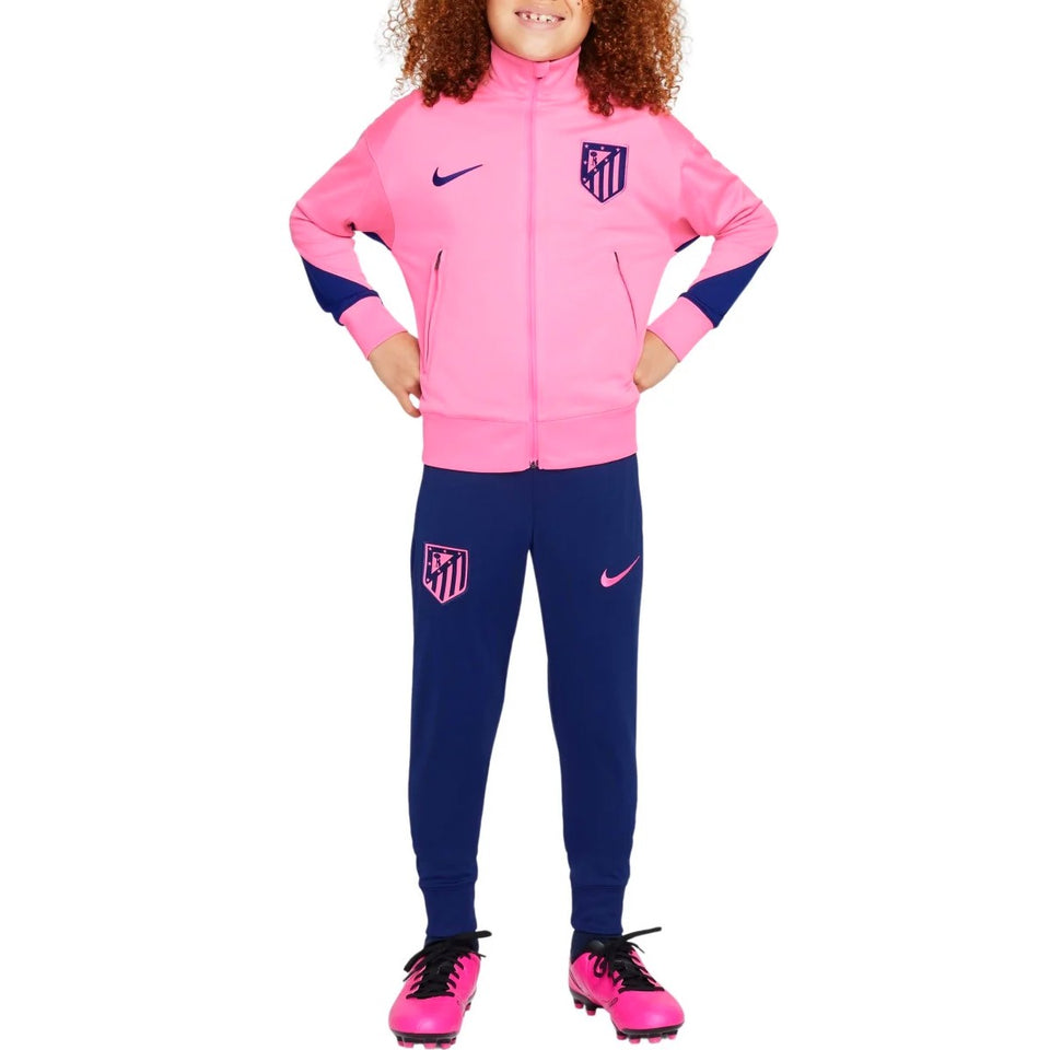 Kids Atletico Madrid tracksuit 2024 in pink and navy blue worn by child model on SoccerTracksuits.com